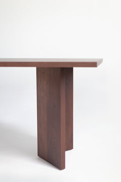Side profile of the Triad walnut dining table showing its solid wood top