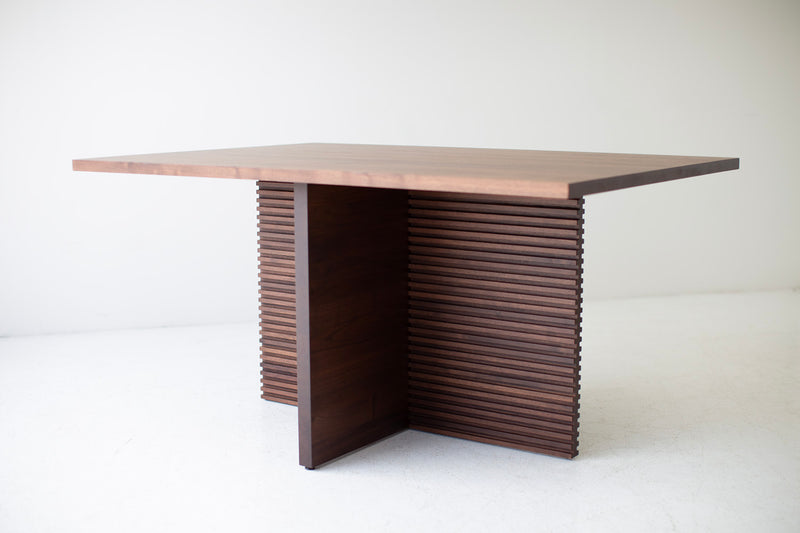 The Cicely, a modern walnut pedestal dining table with a horizontal routed leg pattern