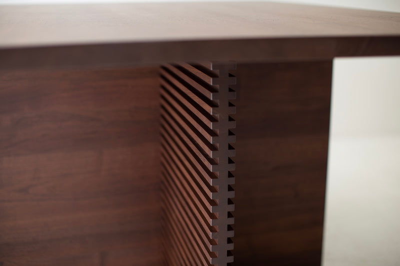 Close-up of the routed pattern detail on the Cicely walnut pedestal table's base