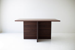 Side profile of the Cicely walnut dining table showing its chunky pedestal legs