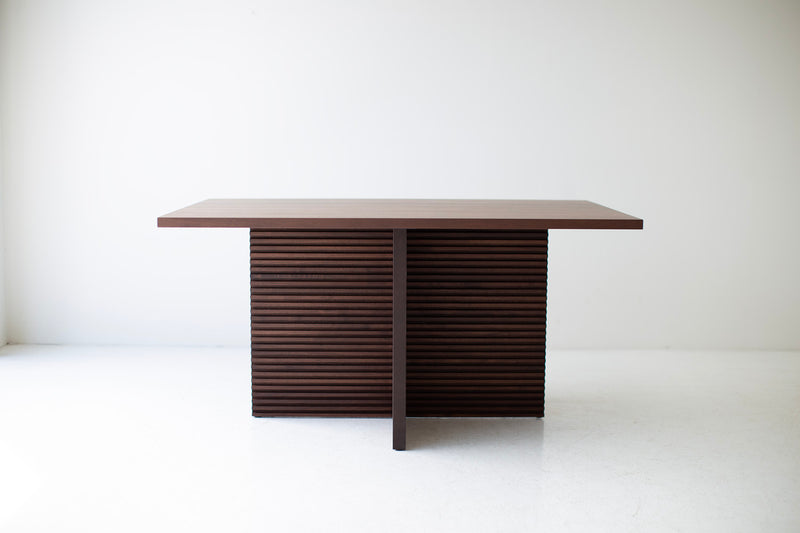 Side profile of the Cicely walnut dining table showing its chunky pedestal legs