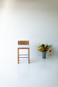Modern luxury white oak counter stools lined up at a kitchen island