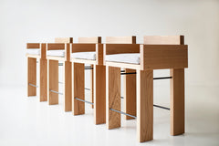 Modern luxury white oak counter stool with arms and a slim black metal frame