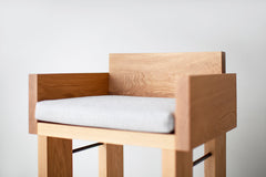 Front view of the white oak Chile counter stool with its cushioned seat