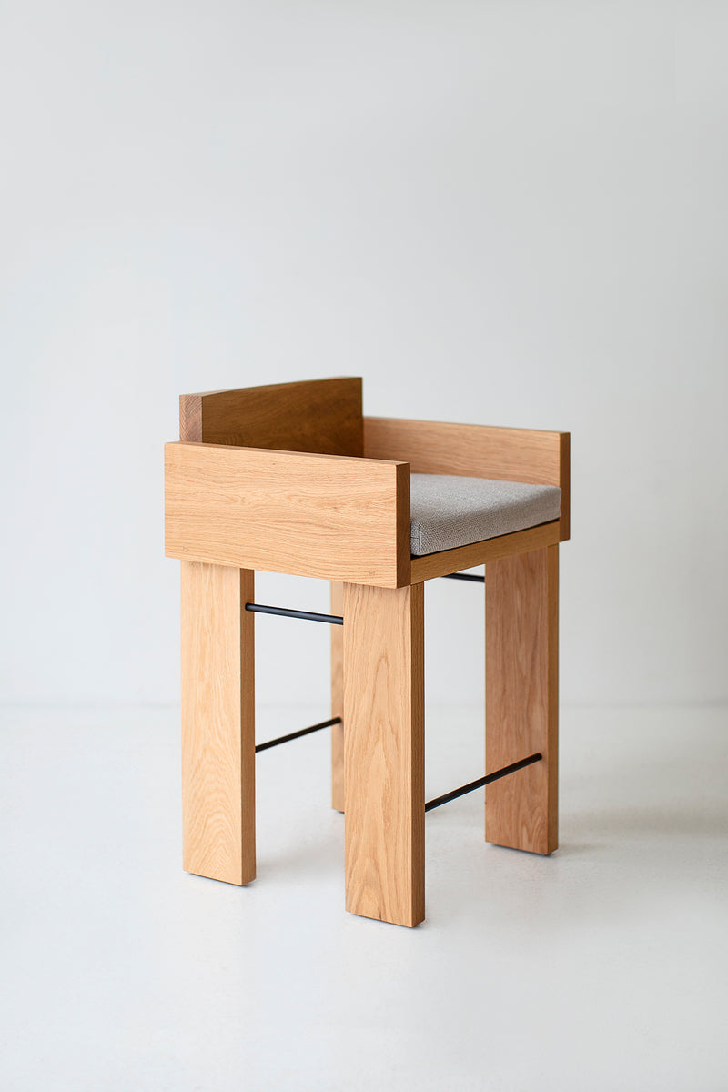Three-quarter view of the counter stool and its chunky wood arms