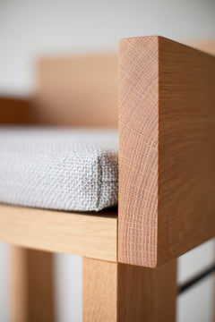 Modern luxury white oak counter stools with arms lined up at a kitchen island