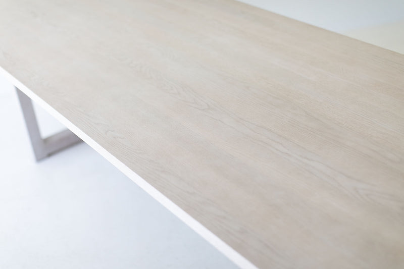 Modern white oak dining table with whitewash finish, shown at an angle