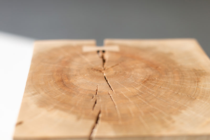 Wood side table with bowties styled next to an armchair