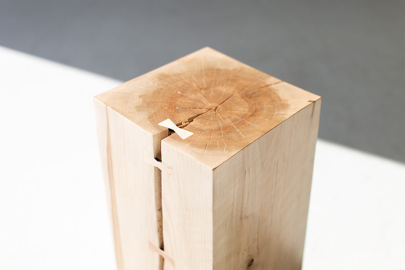 Angled view of the wood side table with bowties displaying its rustic-modern character