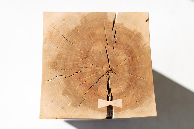 Three wood side tables with bowties grouped together in graduated heights