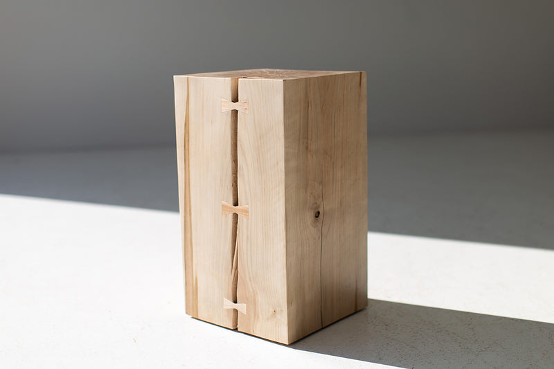 Full view of the wood side table with bowties styled with a lamp on top