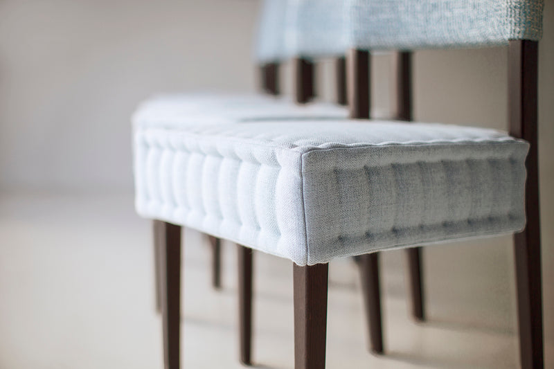 Front view of an Arceo quilted dining chair showing its padded stitching pattern