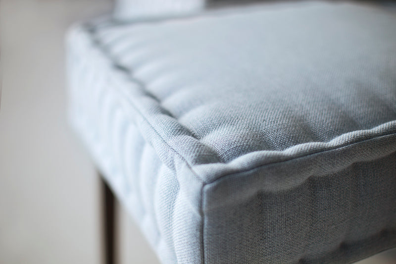Close-up of the quilted leather stitching on a modern dining chair