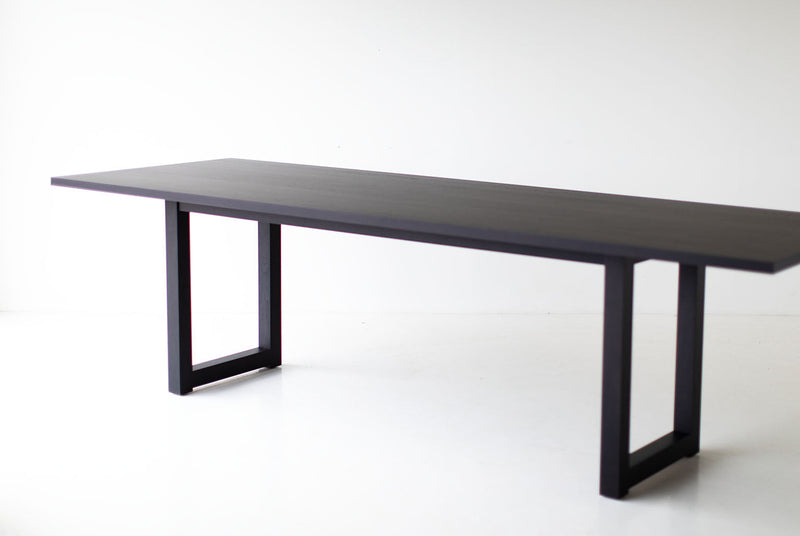 Modern luxury black walnut dining table styled in a modern dining room