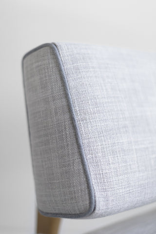 Canadian modern lounge chair in white oak, close-up of the grey linen upholstery and contrast piping