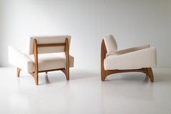 The Canadian modern lounge chair shown in a teak finish, angled view of its low, wide walnut base