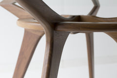 Close-up of the hand-shaped walnut base on this modern dining table