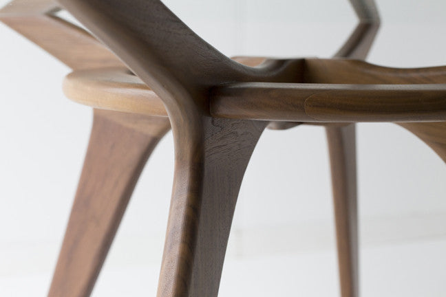 Close-up of the hand-shaped walnut base on this modern dining table