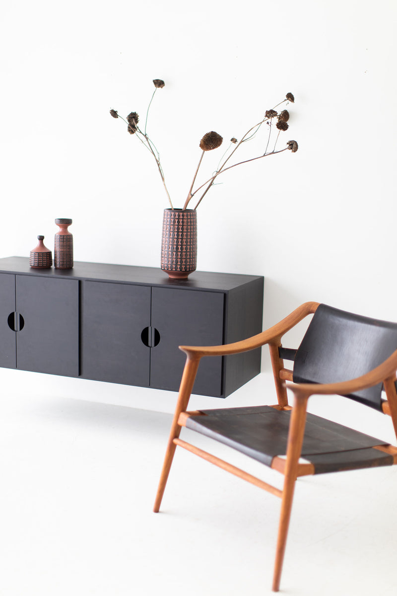 Angled view of the modern floating walnut storage cabinet