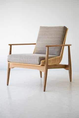 Lawrence Peabody 1806P wicker lounge chair in white oak, angled view showing tapered oak legs and sculpted arms