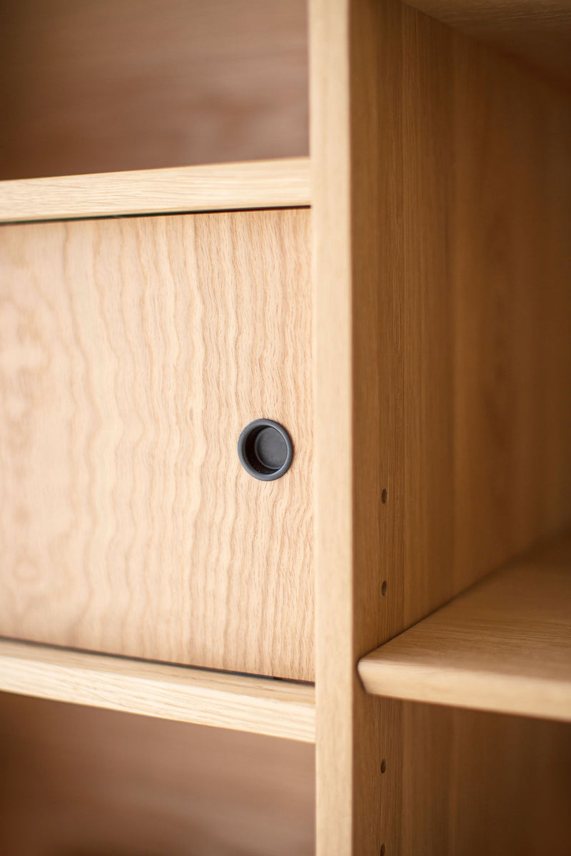 Side profile of the Lawrence Peabody oak bookcase showing its low, elongated frame