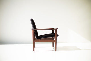 Side profile of the walnut Lawrence Peabody 2360P occasional chair showing its sculpted arm and black upholstered seat and back