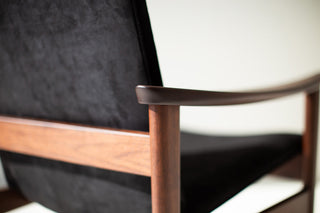 Close-up of the sculpted walnut arm and black upholstery on the Lawrence Peabody 2360P occasional chair