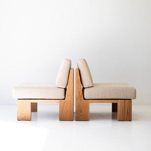 may include - modern luxury oak lounge chair with minimalist design, featuring clean lines and simple sleek shape. Chair sits in a clean white room with white floors. The overall aesthetic is modern. 03
