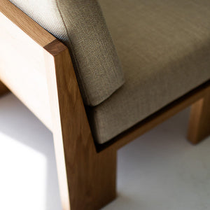 may include - modern luxury oak lounge chair with minimalist design, featuring clean lines and simple sleek shape. Chair sits in a clean white room with white floors. The overall aesthetic is modern. 04