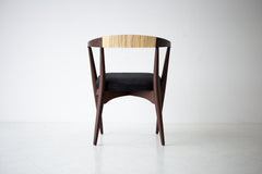 The chair seen from behind, showing the woven cane backrest