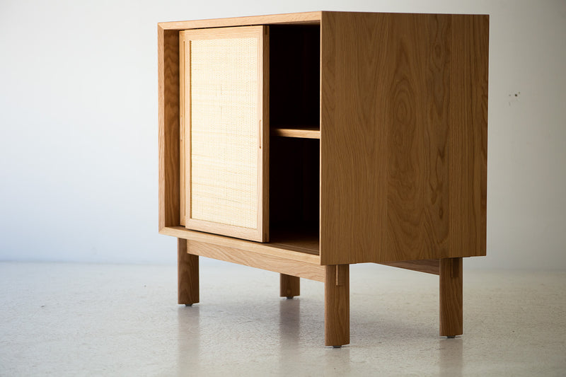 Angled view of the modern Peabody cane front cabinet in solid oak