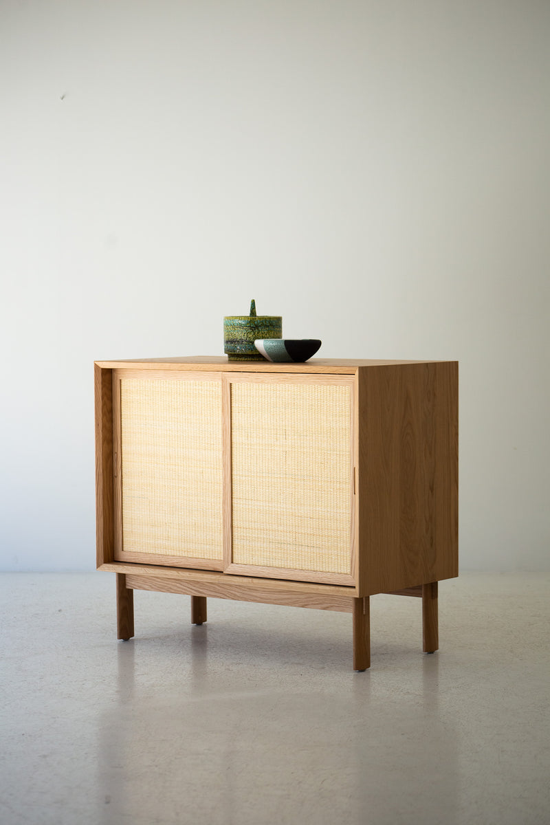 The modern cane front cabinet styled with objects on top