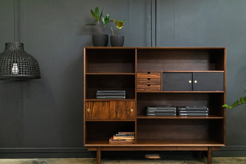 Modern walnut bookcase shown from a low angle