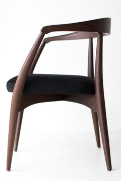 The arm chair seen from behind, showing its continuous curved walnut frame