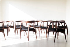 Modern luxury leather and walnut dining arm chairs styled around a dining table