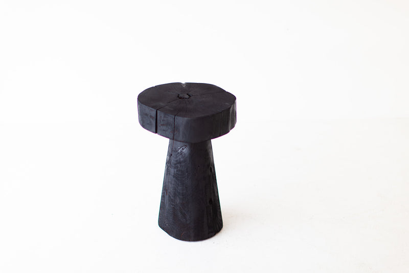 Modern luxury burnt wood stump table styled next to a sofa