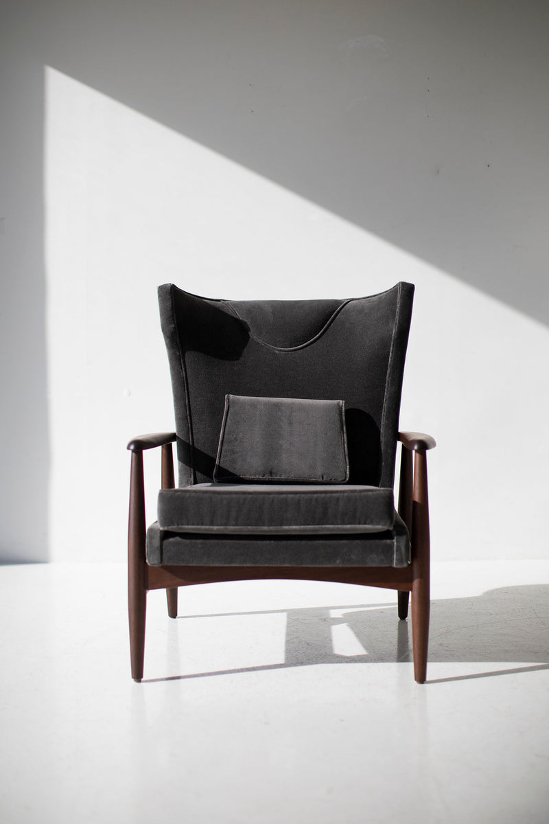 Close-up of the wing chair's splayed solid-wood legs