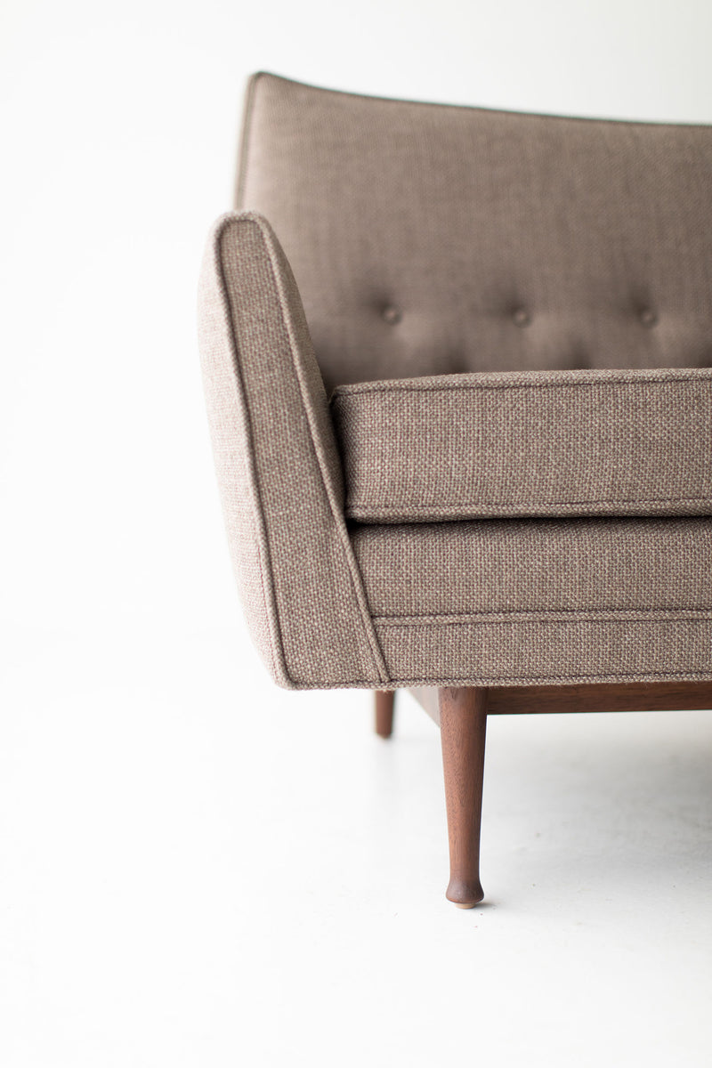 Close-up of the sofa's tapered walnut legs