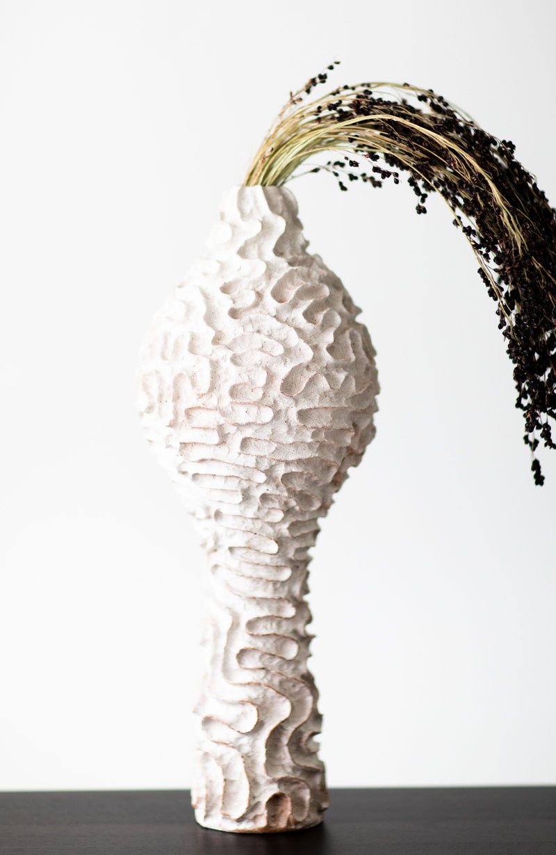 Angled view of the Suzy Goodelman tall ceramic vase