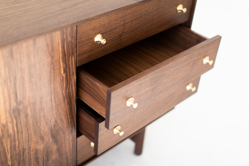 Detail of the turned brass pulls on the modern luxury walnut Peabody credenza
