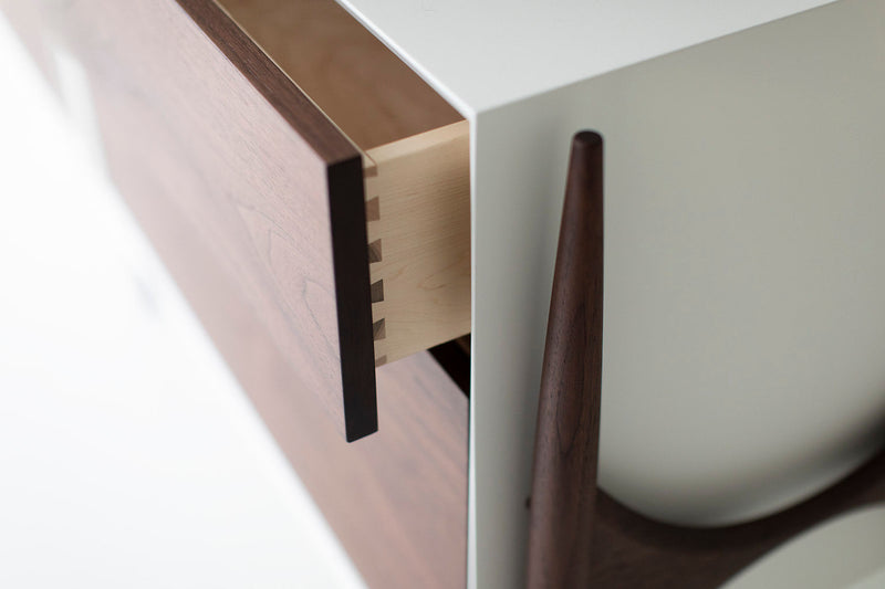 Detail of the lacquered maple frame and solid walnut legs on a modern luxury dresser