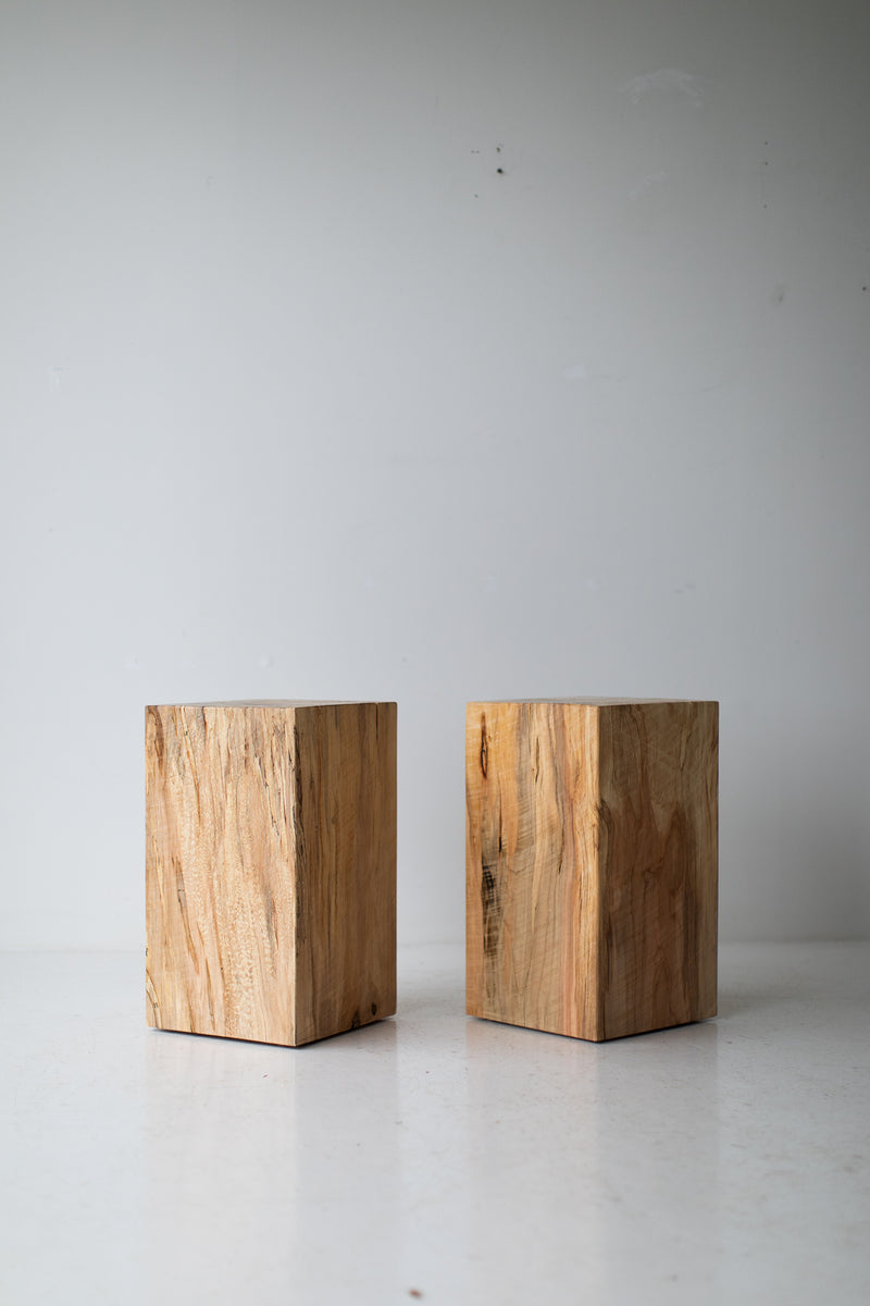 Maple stump used as a nightstand beside a bed