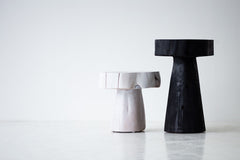 The Summit stump table used as a modern nightstand beside a bed