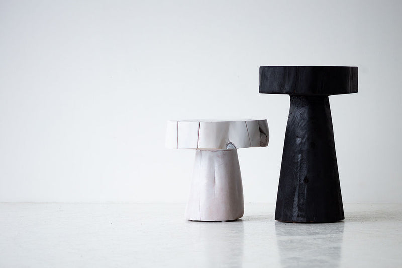 The Summit stump table used as a modern nightstand beside a bed