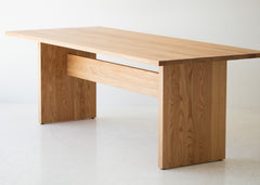Modern luxury white oak dining table styled in a bright dining space