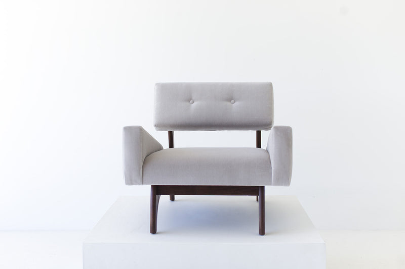 Side profile of the Canadian lounge chair showing its splayed walnut legs