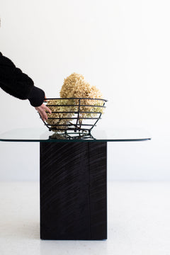 Modern glass-top stump coffee table styled with decor