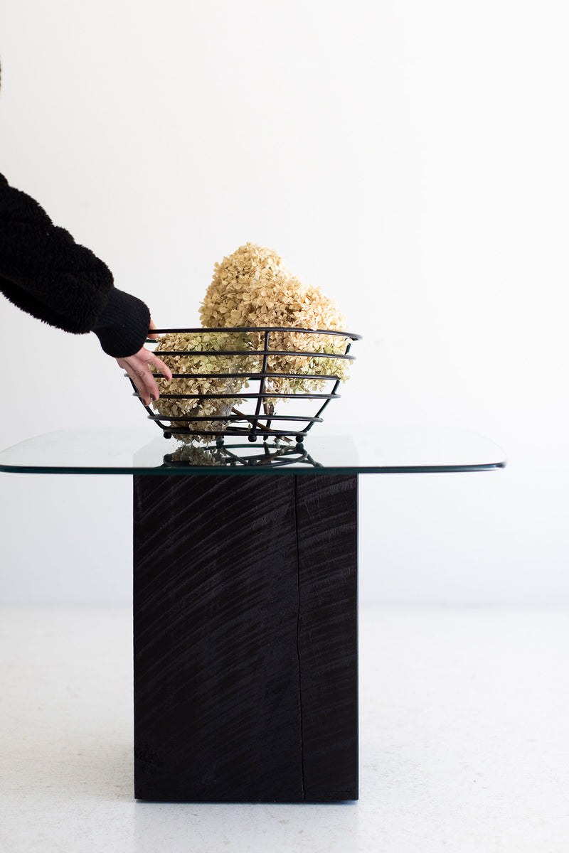 Modern glass-top stump coffee table styled with decor
