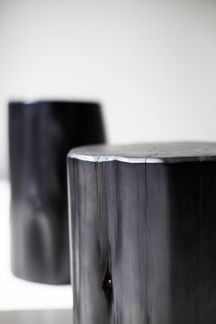 Black red cedar stump side table photographed at a three-quarter angle