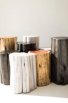 Three black stump tables grouped together as a modern coffee table